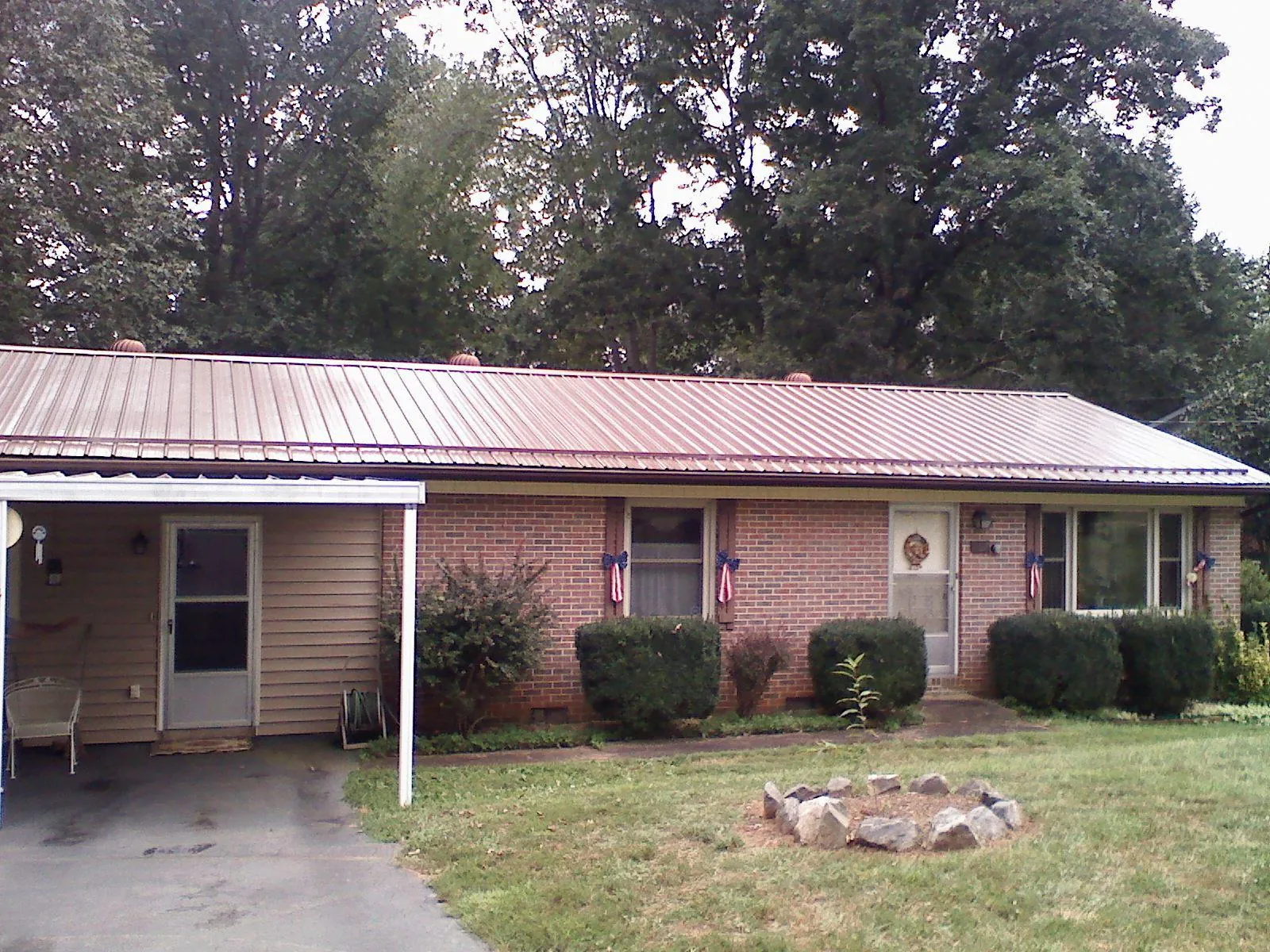 Bronze metal roof and carport on a brick ranch home — Roof Repair work by our crew in Mantachie