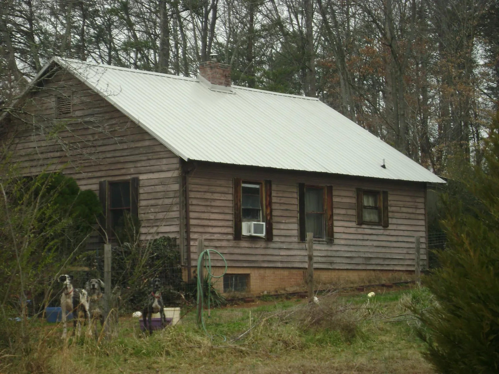 White metal roof on an old wood sided farmhouse, from a Metal Roof Installation job in Mantachie
